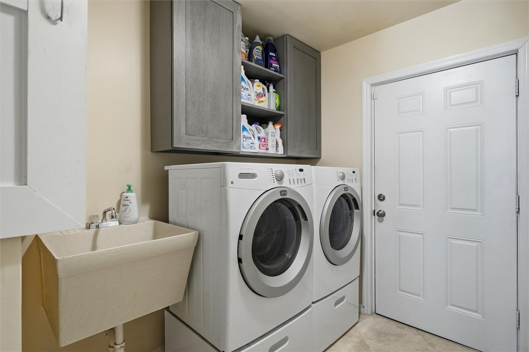 Washer and dryer room with sink and storage includ