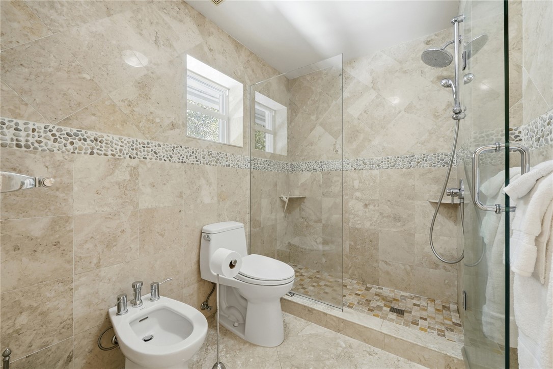Full bathroom featuring tile walls, a stall shower
