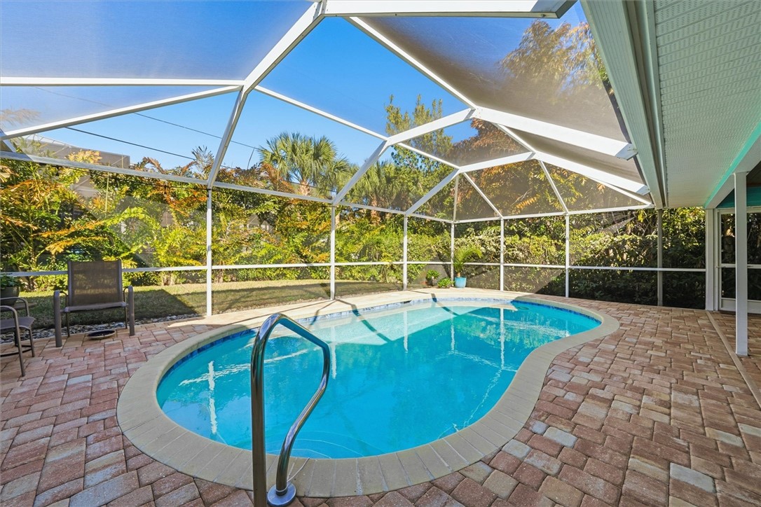 Outdoor pool with screened enclosure and pavers