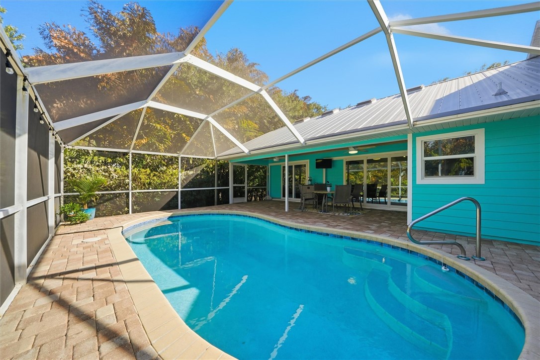 Swimming pool with a patio, a sunroom, and glass e