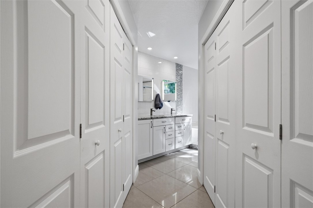 Hallway from primary suite to bath with 2 large wa