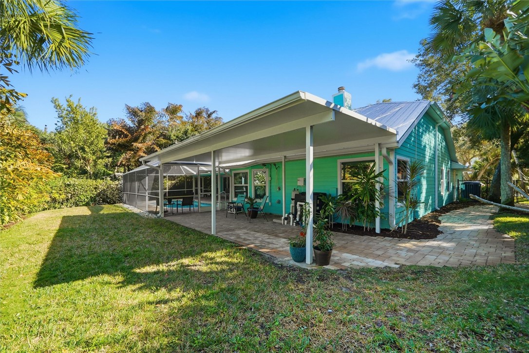 Rear view of property, fenced yard and tropical la