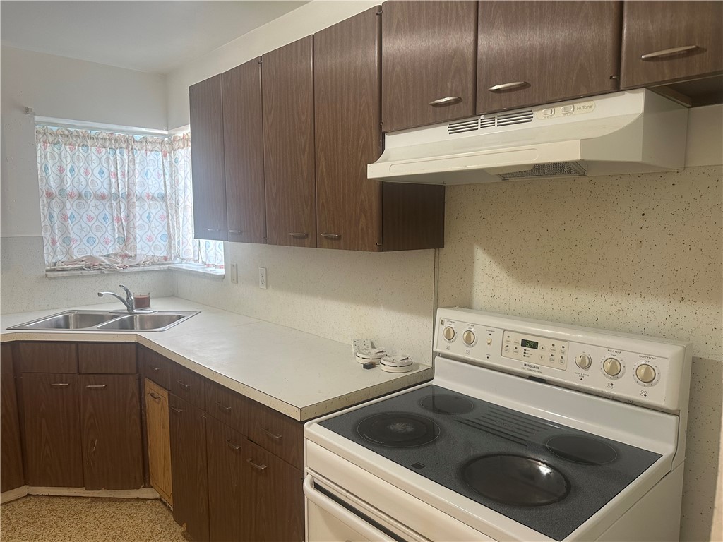 Kitchen with white range with electric cooktop, da