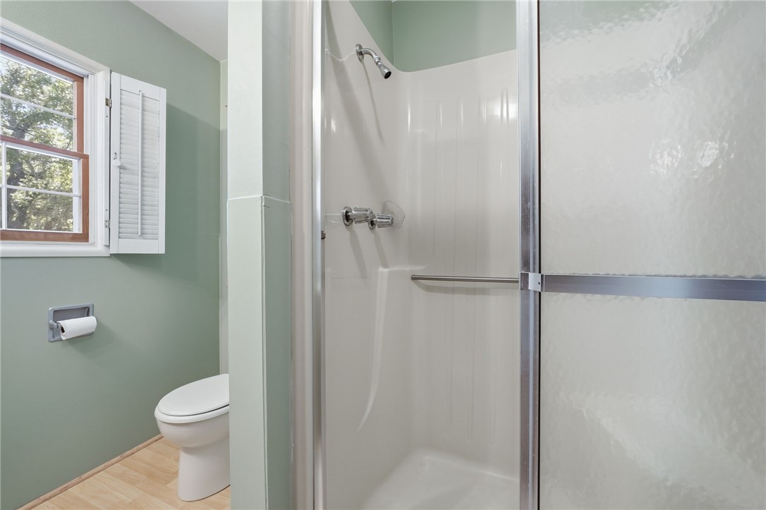 Bathroom featuring a shower with wood flooring