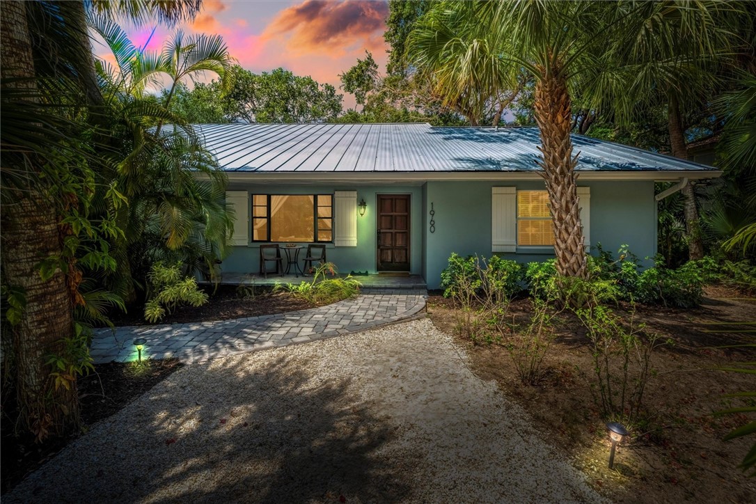 Coastal-style home with a metal roof and light blu