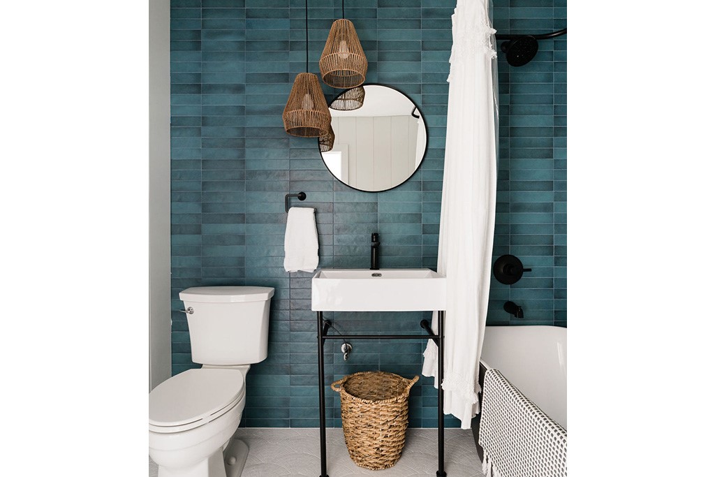 Bathroom featuring blue subway tile, a freestandin