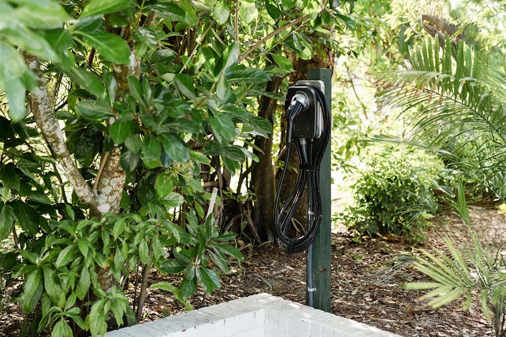 Outdoor EV charging station with a neatly coiled c