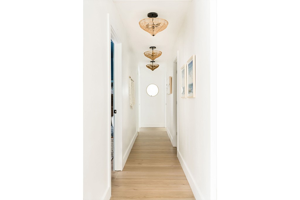 Hallway featuring light wood-finish flooring, whit