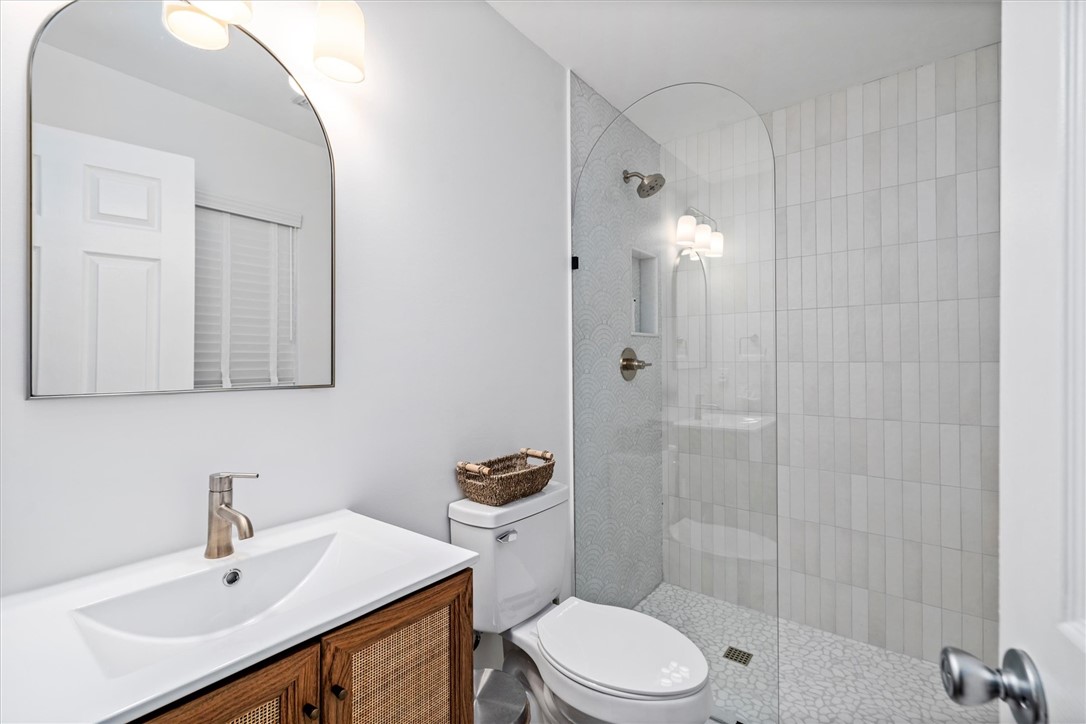 Modern en suite 2nd bathroom featuring a glass-enc