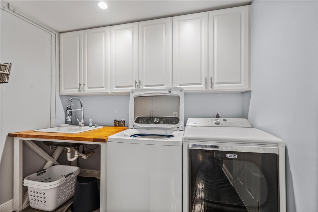 Laundry area featuring white cabinetry, a utility
