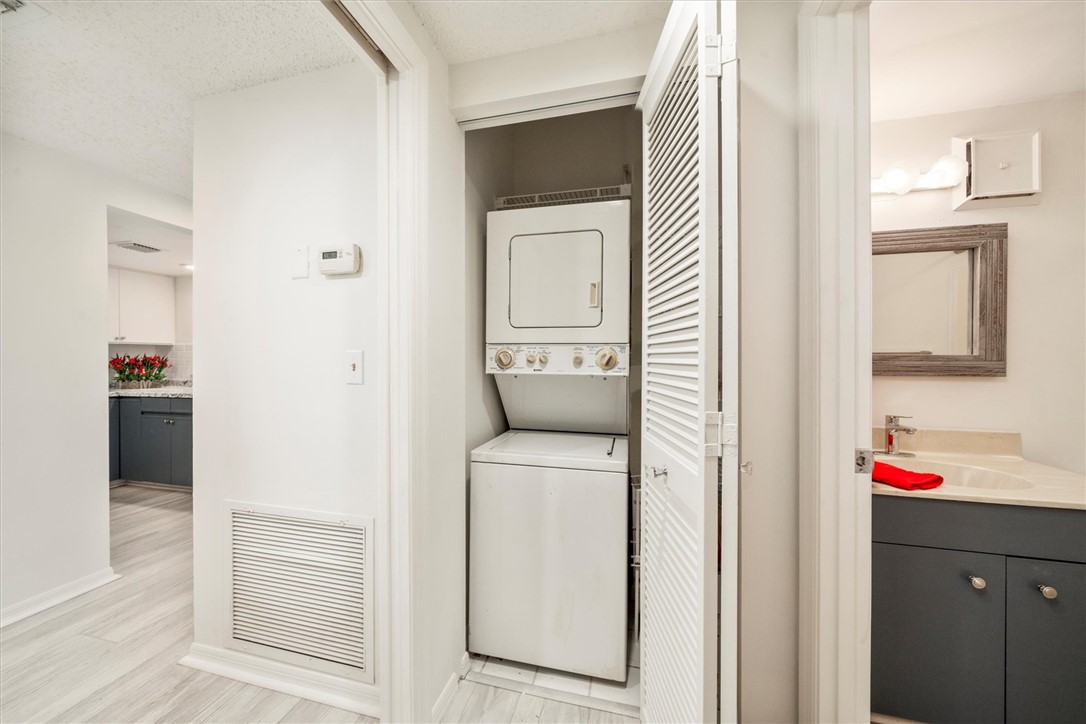Compact laundry area featuring a stacked washer an