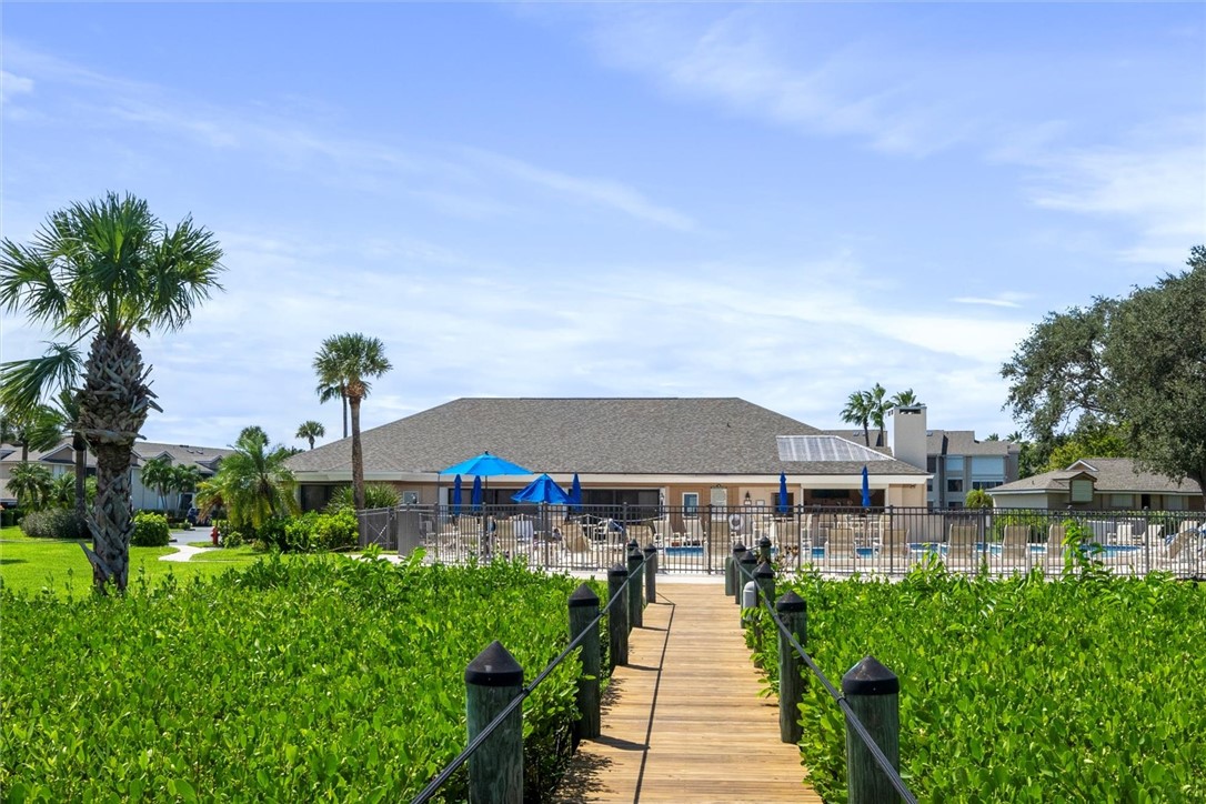 Wood-plank walkway leading to a community pool are