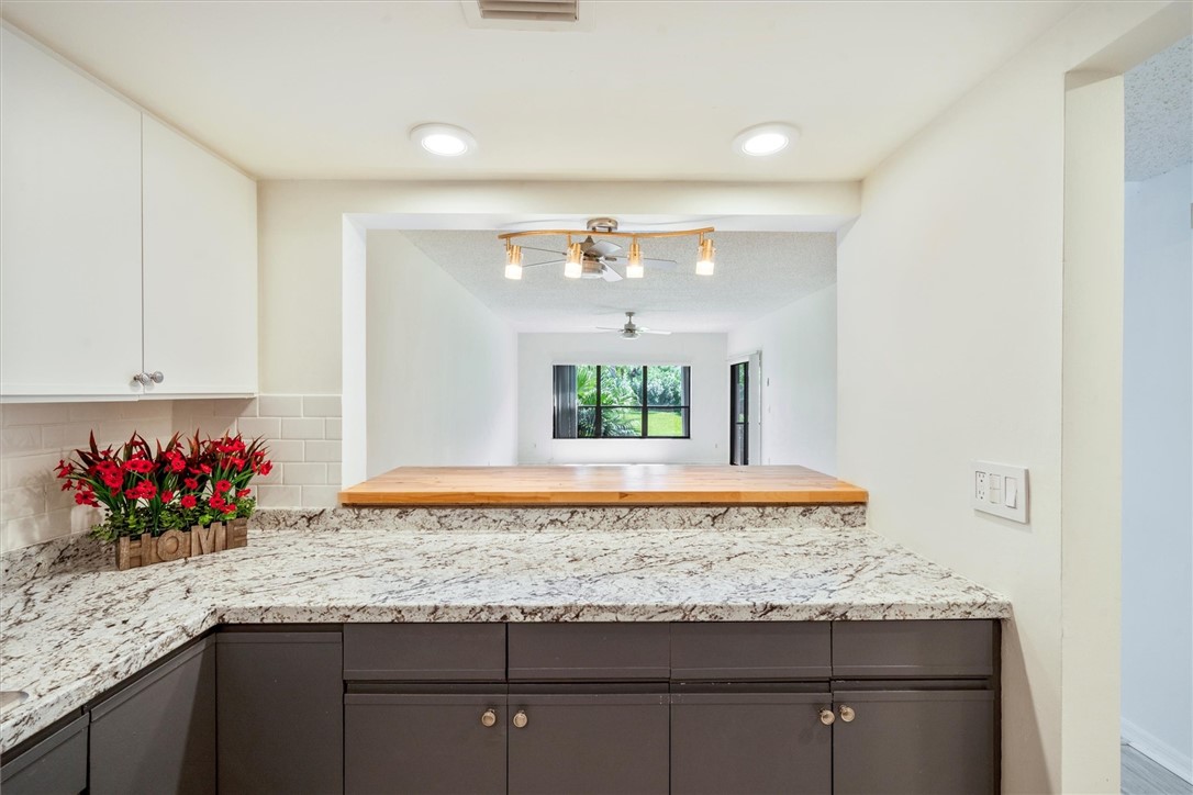 Kitchen pass-through featuring stone countertops,