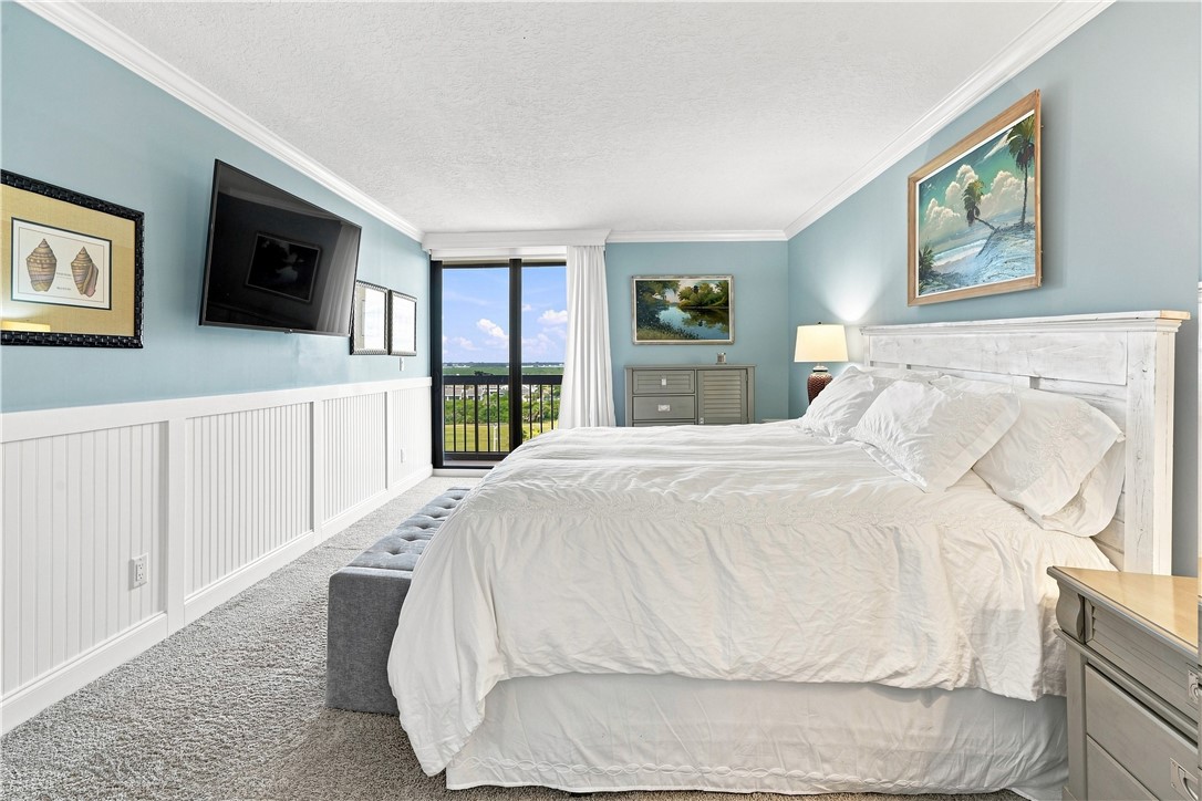 Primary bedroom with white bead board, plush carpe