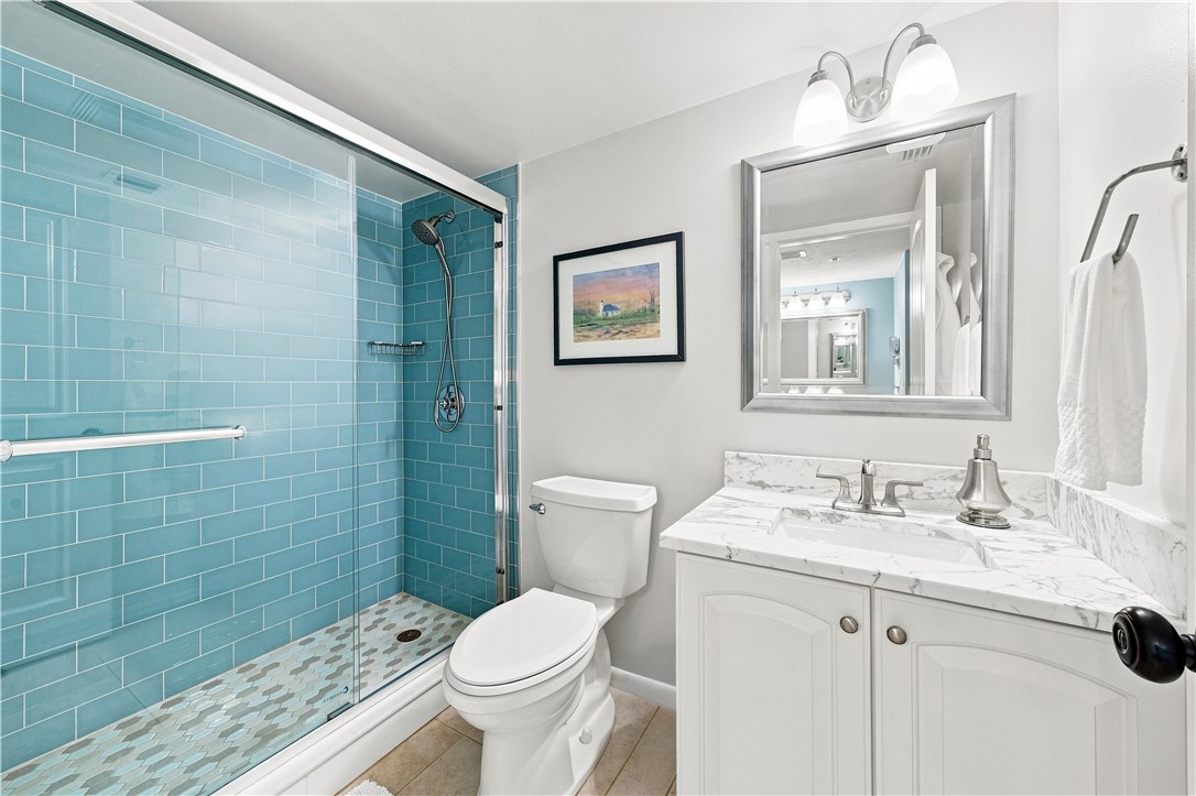 Primary Bath with glass enclosed shower with blue